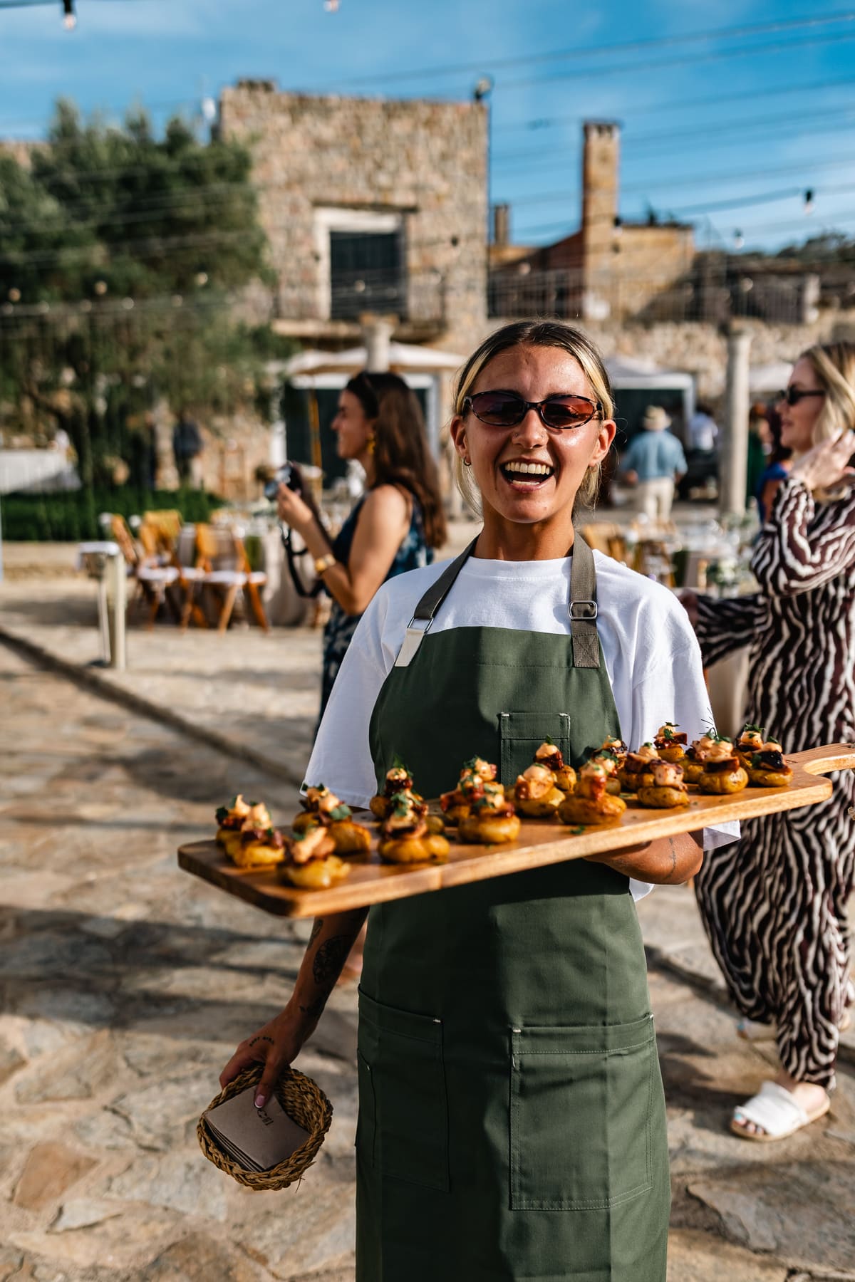 Camarera sonriente sirviendo canapés en un evento