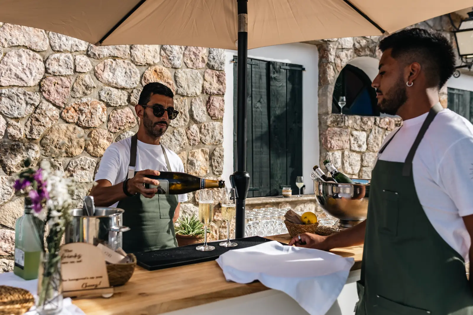 Bartenders sirviendo cava en una barra al aire libre
