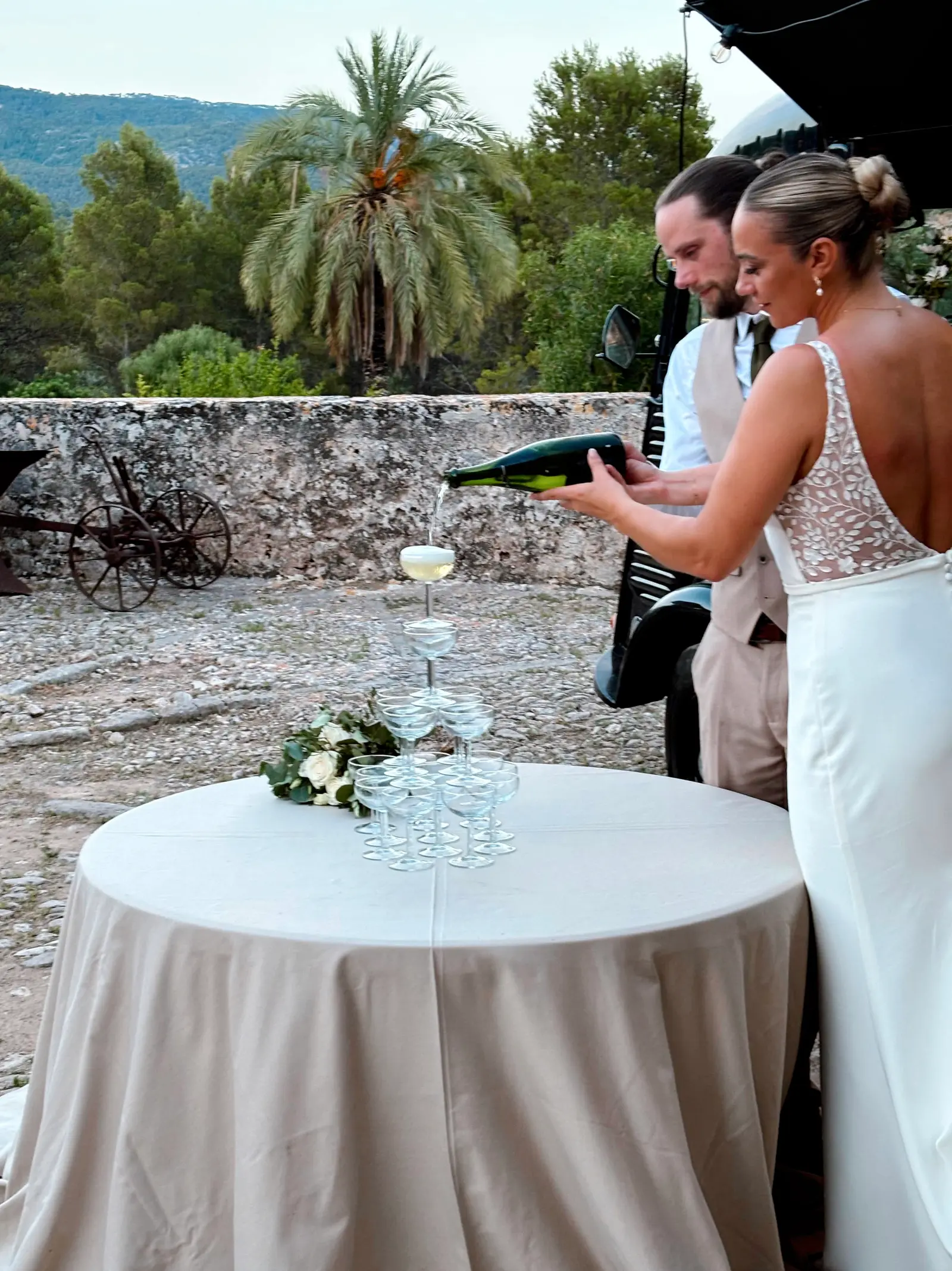 Novios sirviendo una torre de cava en su boda