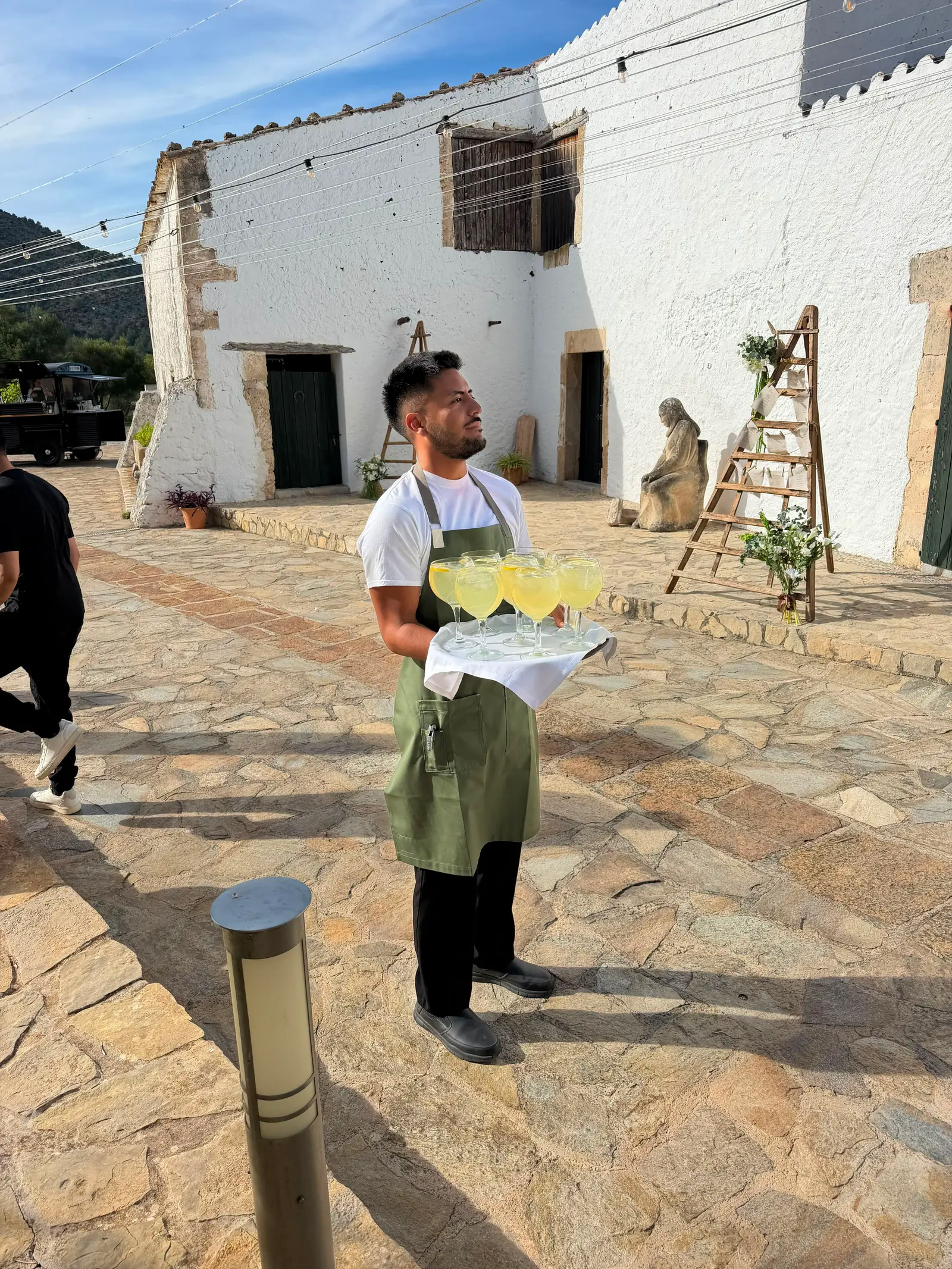 Camarero con bandeja de limonadas en un patio