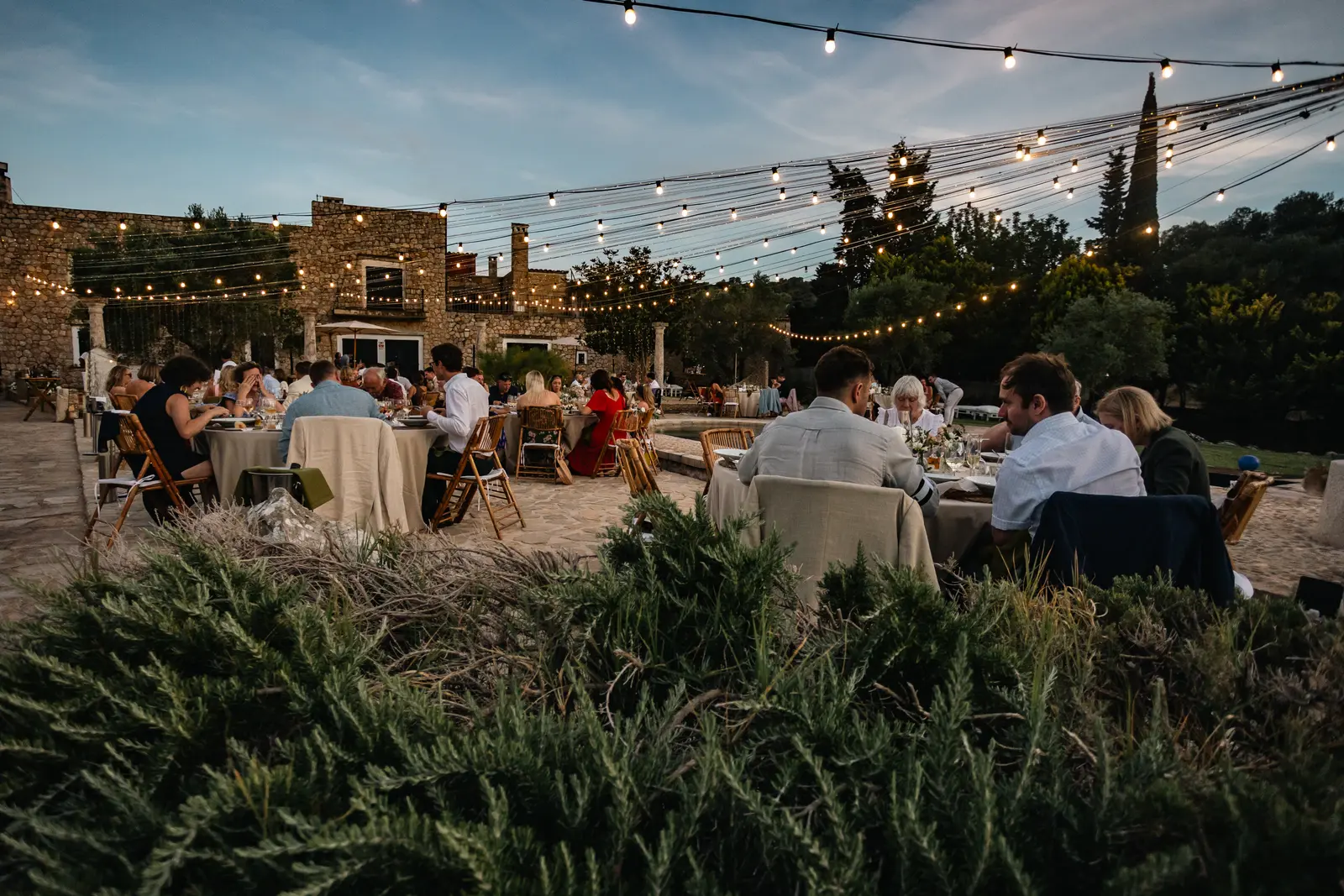 Cena de empresa al aire libre en una finca con luces